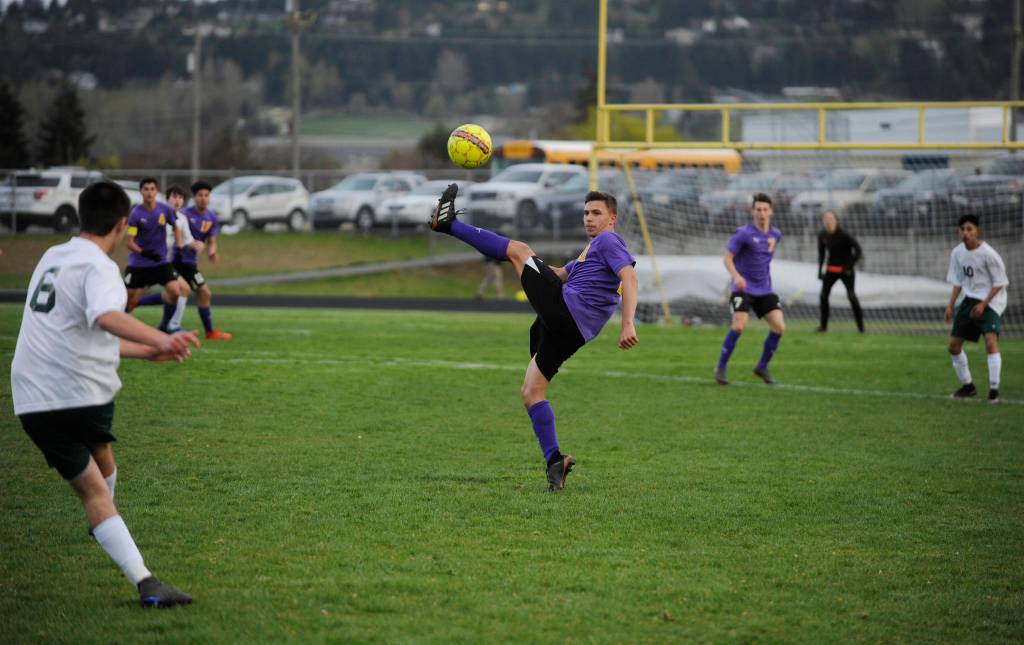 Sequims Mathys Tanche, center, looks to deflect a free kick from Port Angeles Kaleb Baier in the Wolves 1-0 win on April 9. Sequim Gazette photo by Michael Dashiell
