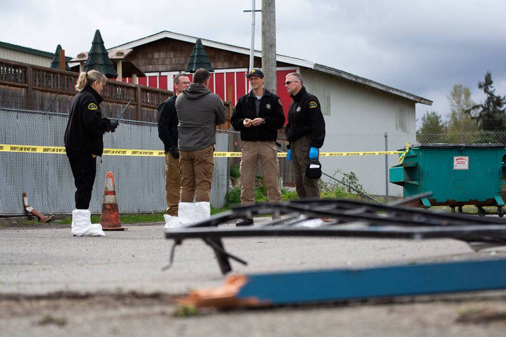 FREDS Guns owner Seth Larson talks to Clallam County Sheriffs detectives after someone drove a loader through his store and stole about 20-30 handguns. (Jesse Major/Peninsula Daily News)