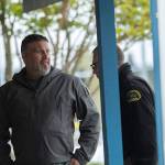 FREDS Guns owner Seth Larson talks to Clallam County Sheriffs detectives after someone drove a loader through his store and stole about 20-30 handguns. (Jesse Major/Peninsula Daily News)