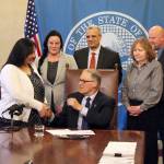 Gov. Jay Inslee signs Sen. Manka Dhingras bill April 17. The bill requires information to be provided to felons on their voting rights after being released from custody. Photo by Emma Epperly/WNPA Olympia News Bureau