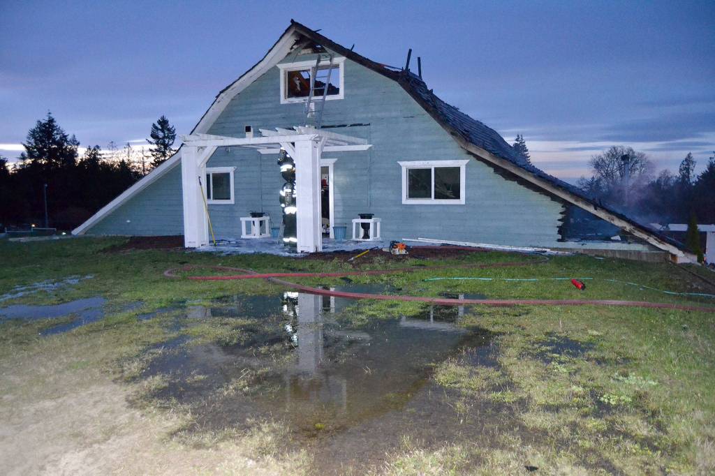 Port Ludlow Fire and Rescue firefighters look for hotspots on Friday night in a Gardiner home on the 2000 block of Old Gardiner Road. Sequim Gazette photo by Matthew Nash
