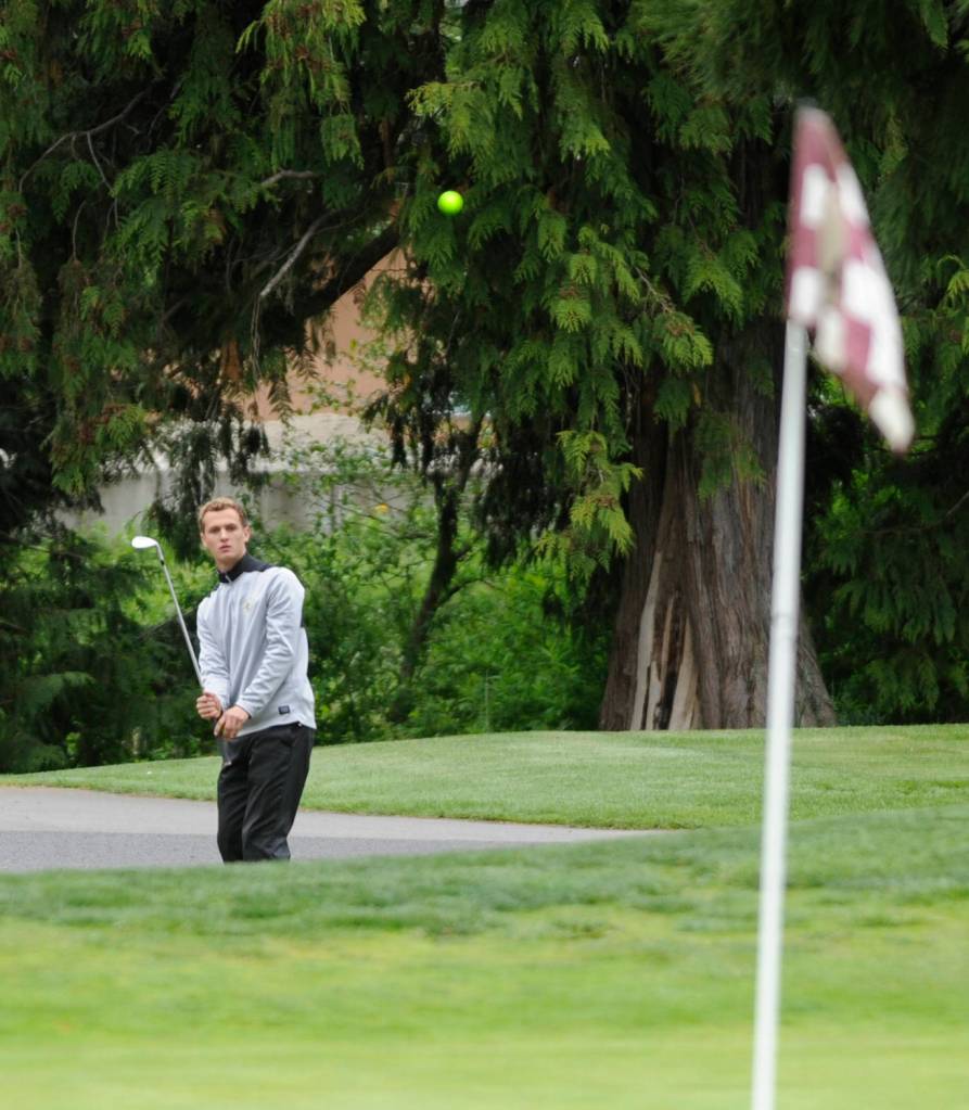 Sequim senior Liam Payne watches a chip shot drop near the first hole at The Cedars at Dungeness on April 23. With the league win that day against North Kitsap, Payne and fellow senior Blake Wiker finished their prep careers unbeaten in league play. Sequim Gazette photo by Michael Dashiell