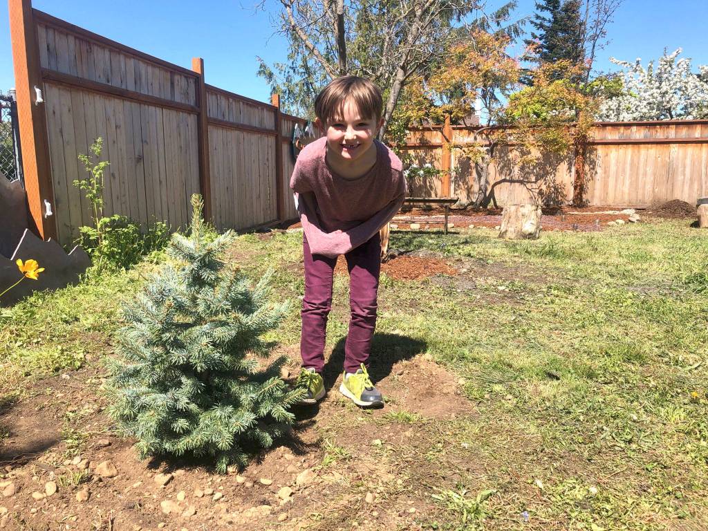 Isaac Stromberg stands by a tree that volunteers planted in his honor at his grandmothers house. The home will soon house women and families facing trauma and crisis. Photo courtesy of Laraine Claire