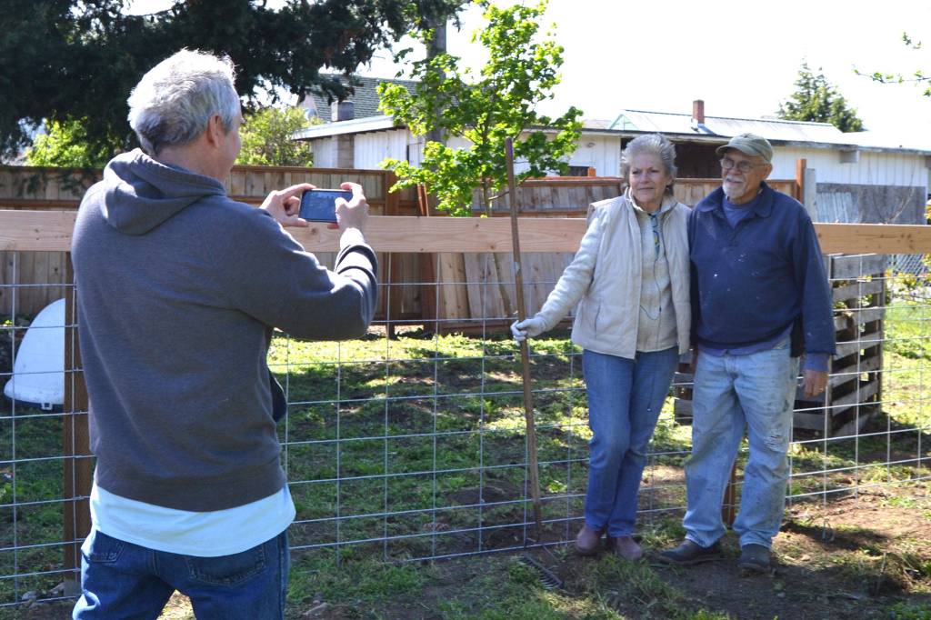 Associate Pastor Rick Dietzman for Sequim Community Church takes a photo of Bob McGovern and Joyce Dennis near the recently completed dog pen at Laraine Claires home. Her house will soon house women and families facing trauma and crisis for the nonprofit ORCA, Our Community Resiliency Alliance. Sequim Gazette photo by Matthew Nash