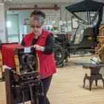 Judy Reandeau Stipe, executive director of the Sequim Museum and Arts Center, moves a camera on display at the museum Sunday. Photo by Jesse Major/Peninsula Daily News