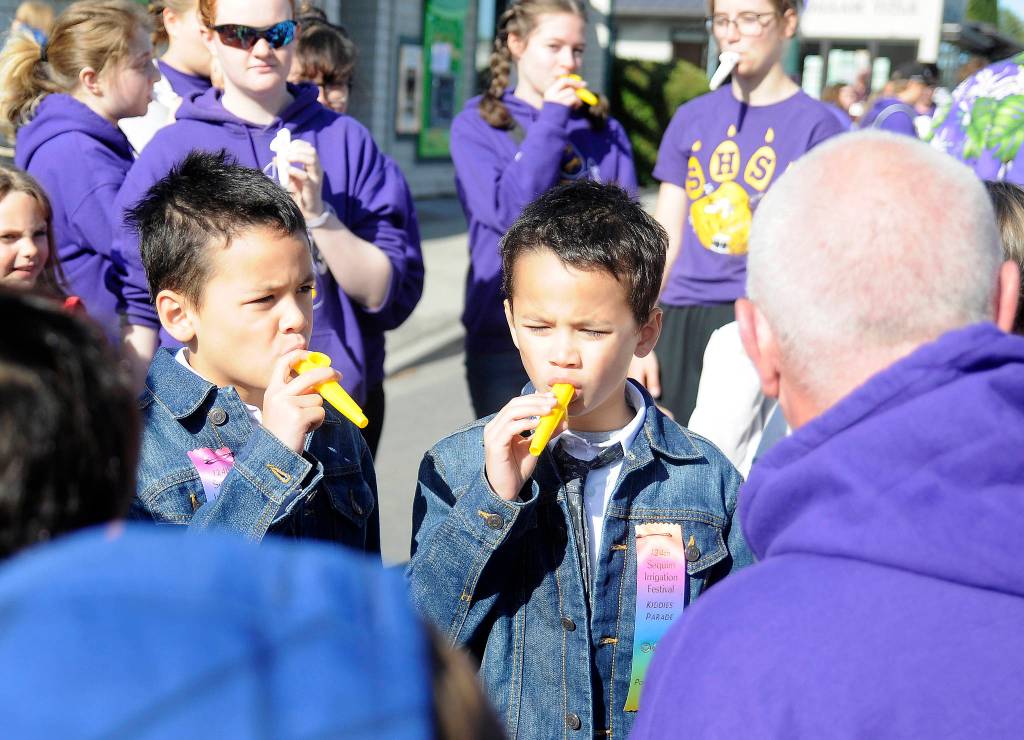 Sequim twins Tokgnar, left, and Tungsten Davis prep their kazoos for the Kids Parade with Vern Fosket, Sequim High School band director. Sequim Gazette photo by Michael Dashiell
