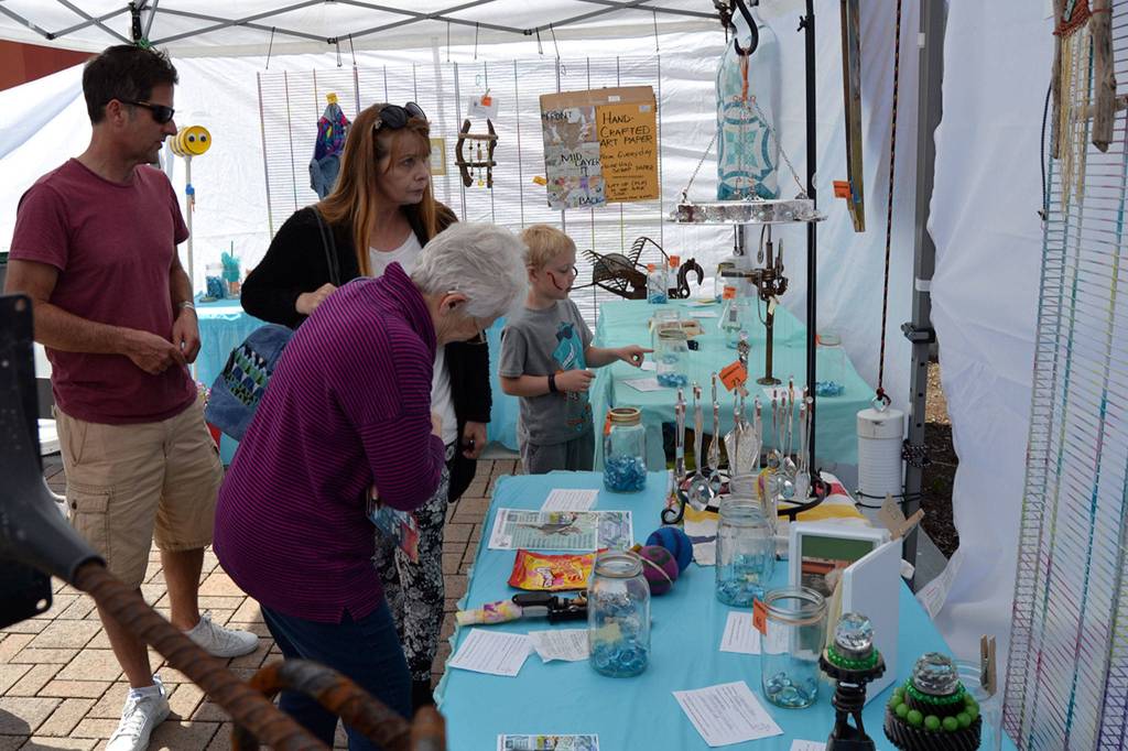 Visitors of the Innovative Arts and Crafts Fair make careful decisions as they vote for their favorite art pieces for the Reuse Showcase. Sequim Gazette photo by Matthew Nash