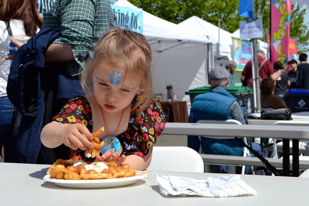 Elianna Baird, 2 ½, of Sequim readies for a bite of delicious churro funnel cake at the food court of the Innovative Arts & Crafts Fair. Sequim Gazette photo by Matthew Nash