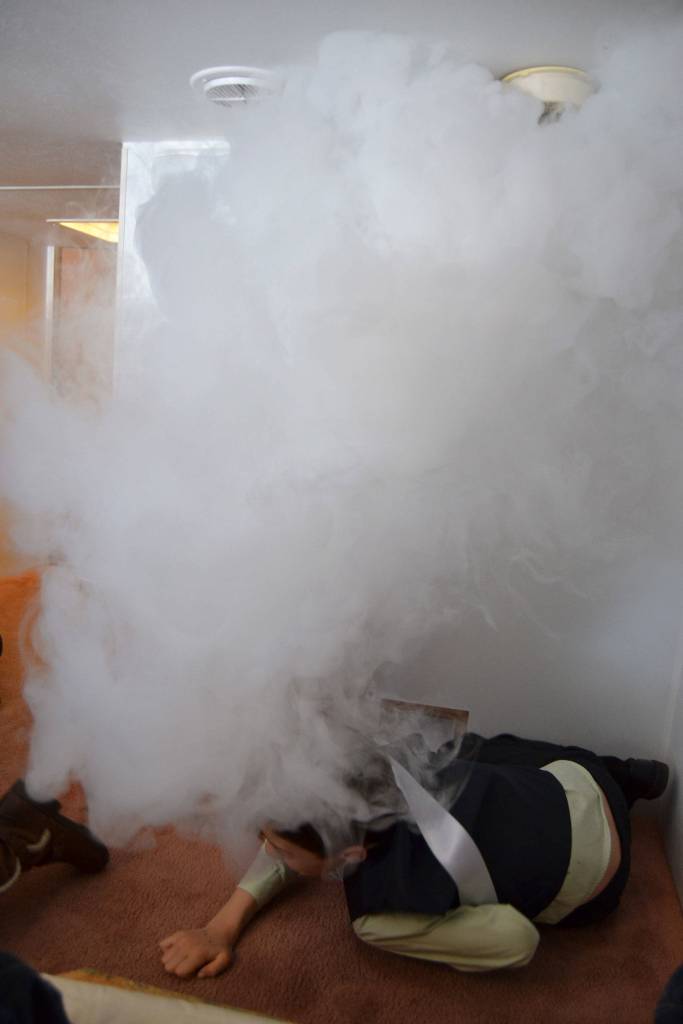Children stop, drop and crawl out of a smoke-filled room inside a fire safety trailer on May 4 during the Family Fun Day. Sequim Gazette photo by Matthew Nash