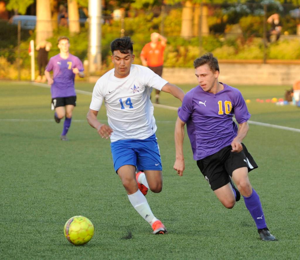 Sequims Mathys Tanche, right, drives deep into Washington territory in the Wolves 4-2 district playoff win on May 7 in Port Angeles. Pursuing the play is Washingtons Obed Lemus. Sequim Gazette photo by Michael Dashiell