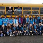 The Interact Club poses in front of a school bus before heading out for one of their service events. Photo provided by Colleen Robinson.