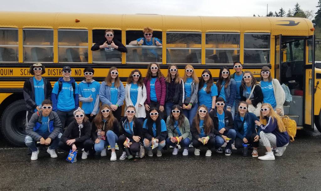 The Interact Club poses in front of a school bus before heading out for one of their service events. Photo provided by Colleen Robinson.