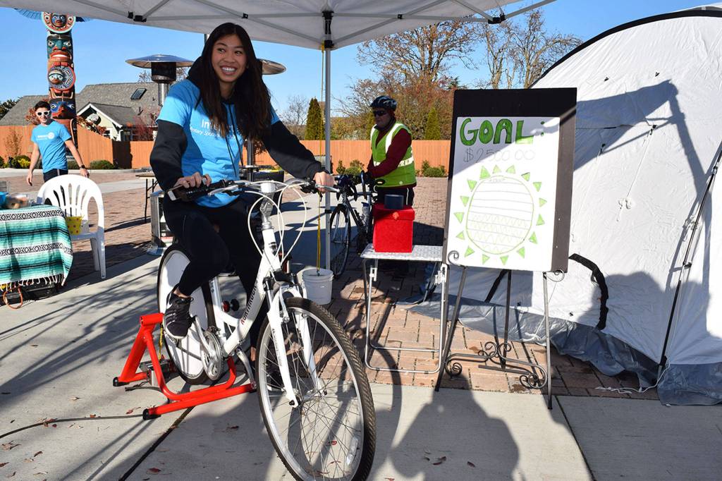 Amanda He, a Sequim High School Rotary Interact Club member, kicks off the Clubs Solar Cyclothon where students pedal on an electricity bike for 24 hours to see how many watts they can generate  in November 2018. SHS students raised funds to purchase 100 solar powered LuminAID lights used in disaster relief efforts and in Shelter Boxes deployed around the world. The students pedaled in 30-minute increments at the Sequim Civic Center Plaza, are demonstrating how much human power it takes to generate LuminAID lights. Sequim Gazette file photo by Erin Hawkins