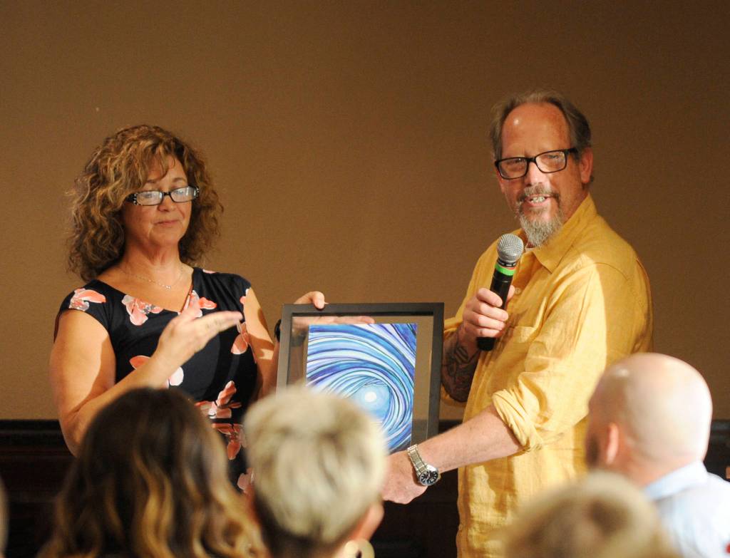 Pepper Fisher, on-air announcer for Newsradio KONP, accepts an award from Lori Taylor of United Way of Clallam County on May 9. Sequim Gazette photo by Michael Dashiell