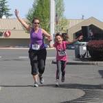 Ceci and Mia Buhrer celebrate as they cross the finish line after finishing the Sequim Irrigation Fun Run 1-mile race on May 11. Sequim Gazette photo by Michael Dashiell