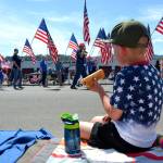 Grayson Castell, 5, enjoys a hot dog courtesy of his familys annual parade barbecue at Castell Insurance during the Sequim Irrigation Festivals Grand Parade. Sequim Gazette photo by Matthew Nash