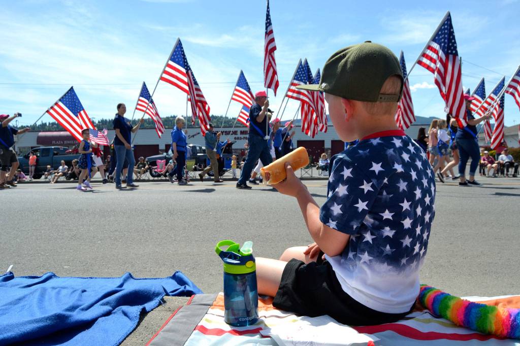 Grayson Castell, 5, enjoys a hot dog courtesy of his familys annual parade barbecue at Castell Insurance during the Sequim Irrigation Festivals Grand Parade. Sequim Gazette photo by Matthew Nash