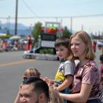 Hailey Collier, 15, holds her nephew River Bogie, 3, as they watch bands and floats go by in the Irrigation Festivals Grand Parade. Sequim Gazette photo by Matthew Nash