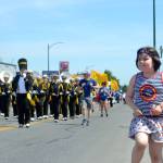 Sophia Mager, 8, of Sequim dances and waves as she listens to bands go by in the Grand Parade. Sequim Gazette photo by Matthew Nash