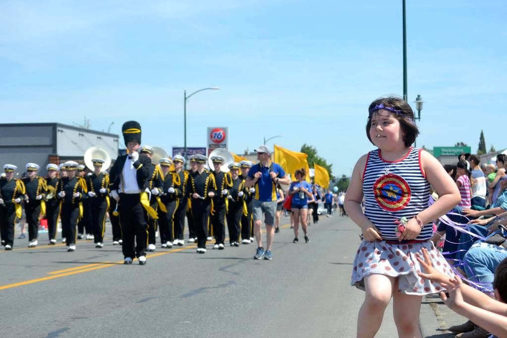 Sophia Mager, 8, of Sequim dances and waves as she listens to bands go by in the Grand Parade. Sequim Gazette photo by Matthew Nash