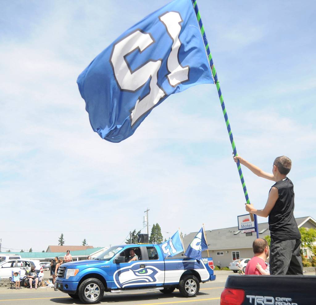 Dalton Ross of Port Angeles waves his 12th Man flag as the Dungeness Seahawkers group passes by during the Sequim Irrigation Festival Grand Parade on May 11. Sequim Gazette photo by Michael Dashiell