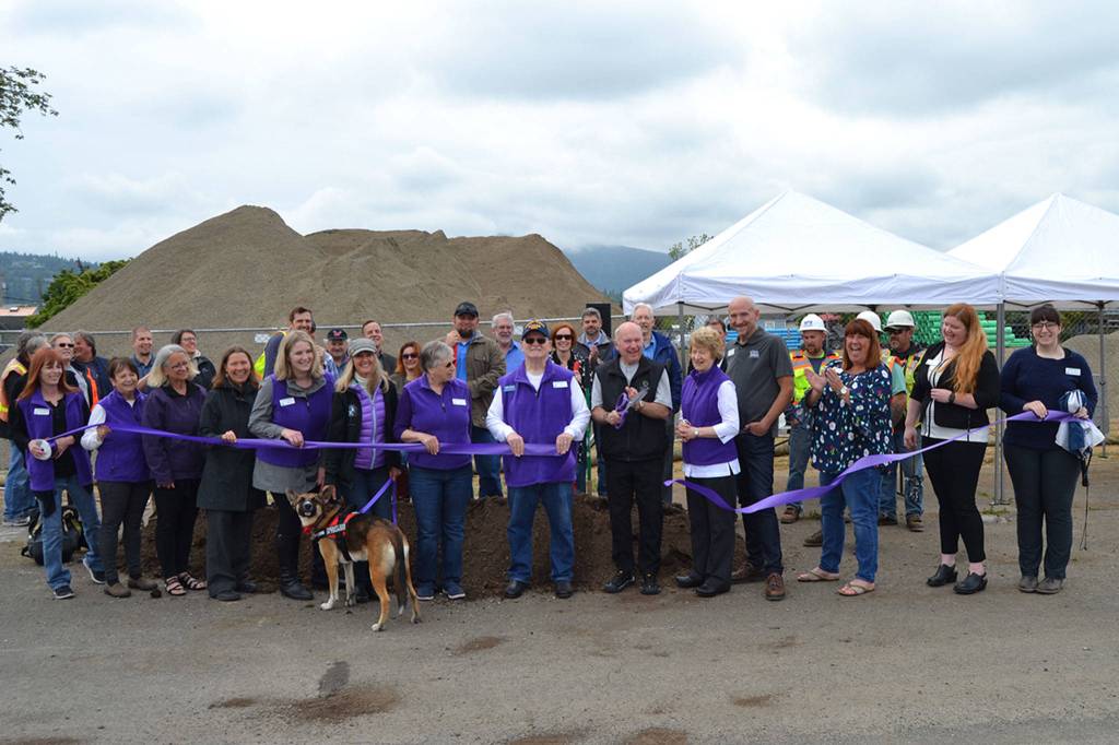 Sequim Mayor Dennis Smith cuts the ribbon on the West Fir Street Rehabilitation Project with members of the Sequim-Dungeness Valley Chamber of Commerce and community members and other dignitaries nearby. Sequim Gazette photo by Matthew Nash