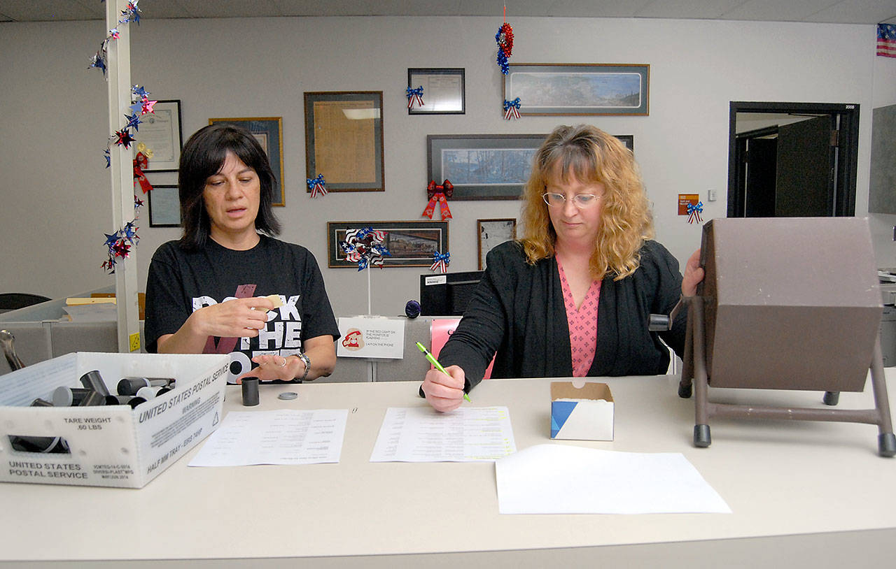 Susan Johnson of the Clallam County Auditors Office, left, reads names drawn by lot as Elections Manager Becky Pettigrew records the order that candidates will appear on the ballot during Fridays lot draw at the Clallam County Courthouse in Port Angeles. (Keith Thorpe/Peninsula Daily News)
