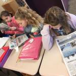 From left, students Anastasia Kovalik, Brooklyn McHaffie-Fatherson and Brooke Piersoll learn about their community from articles in the weekly Sequim Gazette newspaper. Submitted photo