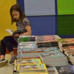 First Grader Brooklyn Pritchett, 7, reads a book during a break as a volunteer for Helen Haller Elementarys Six Books for Summer program. She and hundreds of other students will receive six books in June from Helen Haller PTO to help prevent the summer reading slide. Sequim Gazette photo by Matthew Nash