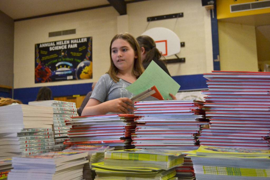 Emma Gilliam, 11, looks for her next book to sort and bag for a second grader as part of Helen Haller Elementarys Six Books for Summer program. Its the third year for the program with funding coming from Helen Haller PTO and community support.