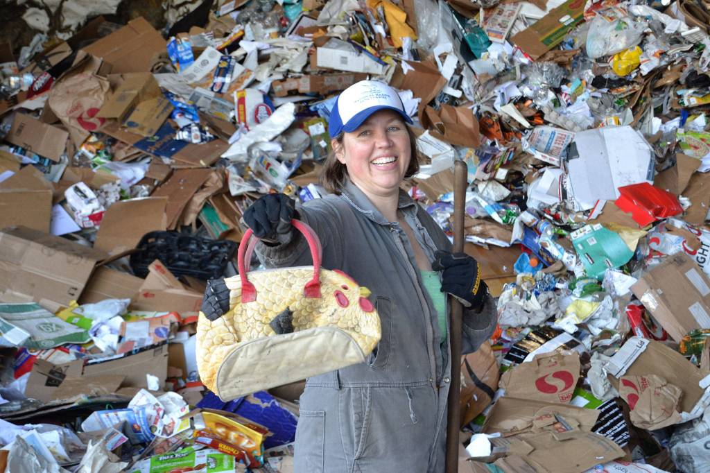 Meggan Uecker, Clallam County solid waste coordinator, can add a rooster purse to her collection of odd finds at the Murreys Reclamation Facility. During a recycling audit, she and others found a baby gate, electric fencing, diapers, and many more odd items in the co-mingling recycling drop-off area.