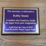 In early 2018, Annabelle Armstrong, left, and Lesae Pfeffer began fundraising to honor the memory of Robby Streett, who died in July 2017 in a car wreck. He would have graduated from Sequim High School on June 7. Here, Armstrong and Pfeffer hold a plaque donated by the Class of 2019 dedicated to Robby. Sequim Gazette photo by Matthew Nash