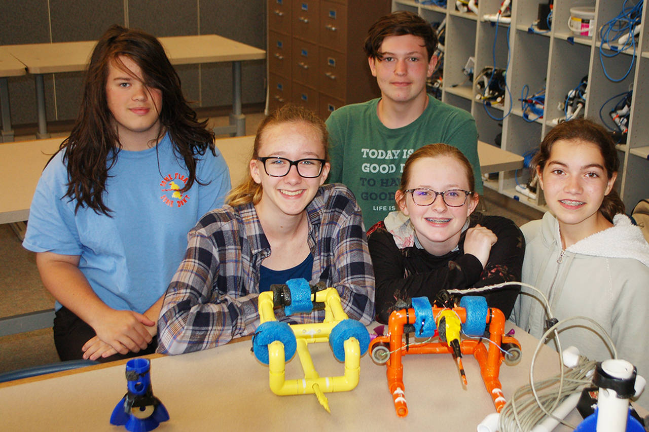 Pictured, from left, Sequim Middle School students Finn Marlow, Julia Jeffers, Desmond Tippins, Ruby Coulson, and Kari Olson pose with their SeaPerch regionals ROV The Banana Boat, left, and their SeaPerch nationals competition ROV the Fire Breathing Rubber Ducky. Sequim Gazette photo by Conor Dowley.