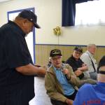 Steve Henrikson, VFW Post 4760 quartermaster, hands World War II veteran Lee Cox a 75th anniversary commemorative coin of D-Day during the VFWs presentation on June 8. Sequim Gazette photo by Matthew Nash