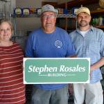 As a surprise, Andra Smith and Mark Ozias, current and former executive director of the Sequim Food Bank, named the bread and meat building after Stephen Rosales, center, for his years of dedication end efforts to help those in-need. Sequim Gazette photo by Matthew Nash