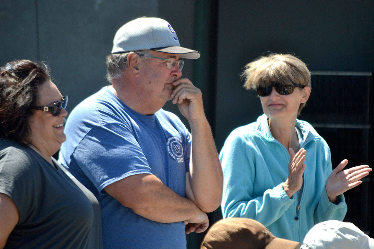 Stephen Rosales, board member for the Sequim Food Bank, learns theyve name the bread and meat building after him on June 15 as his wife Kim, right, and Deon Kapetan, left, congratulate him.