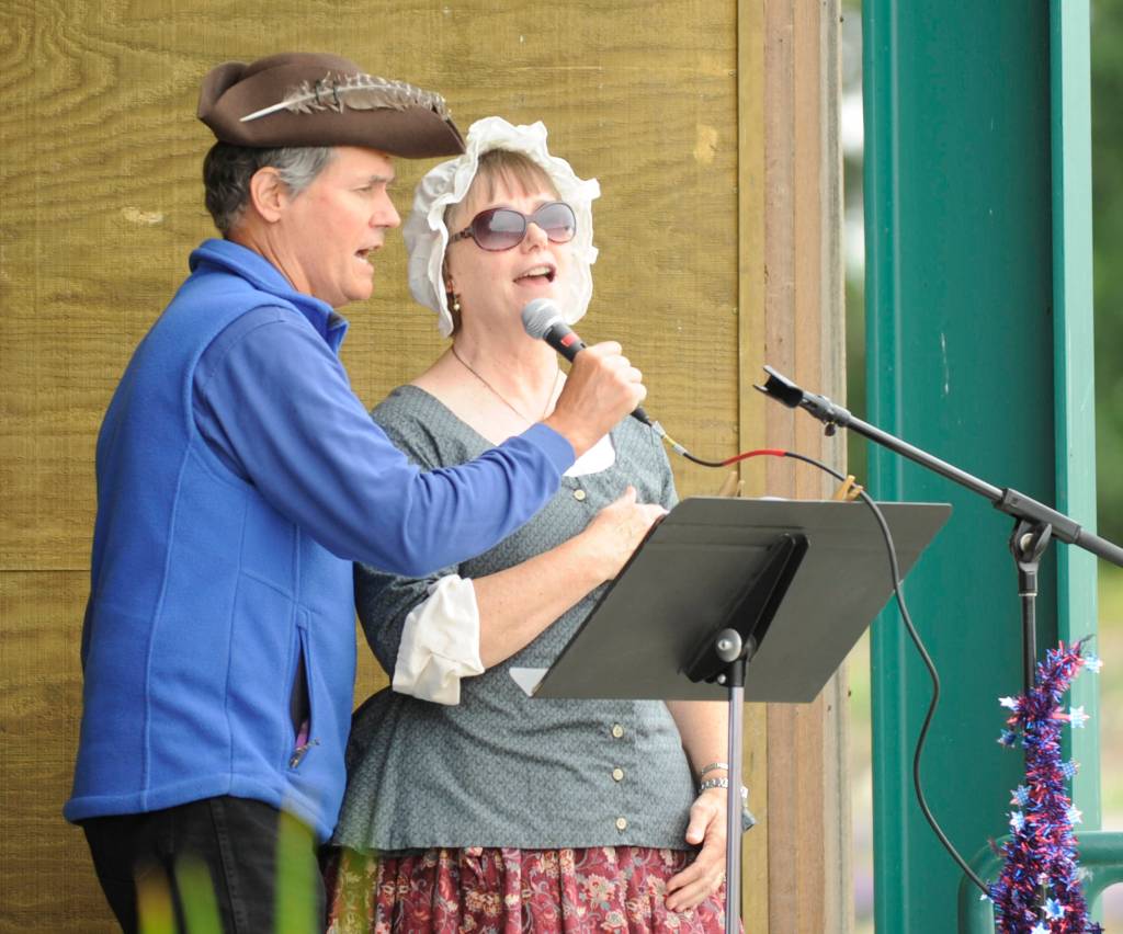 Joel Yelland and Karla Messerschmidt-Morgan help lead the The Star Spangled Banner, while the Sequim City Band plays to open the July 4 A Patriotic Fourth concert.