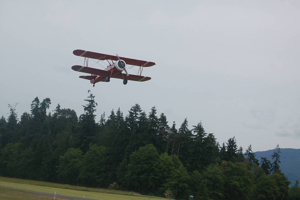 The Red Stearman biplane takes off with retired Navy medievac nurse Janet Ford on its way to fly over The Lodge At Sherwood Village. Clint Cawley flew Ford and seven other Lodge residents on July 9 from Sequim Valley Airport as part of the Ageless Aviation Dreams Foundation experience that Lodge and airport representatives set up for them. Sequim Gazette photo by Conor Dowley.