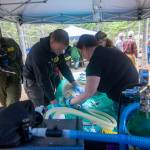Crews hold down a blindfolded mountain goat kid as veterinarians examine it before transport on July 9. Photo by Jesse Major/Peninsula Daily News
