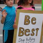 Griffin and Moka Bartch hold a sign asking for federal authorities involved in immigration control to stop bullying children and to stop separating families at a protest lead by Indivisible Sequim at the Port Angeles office of the Customs and Border Protection agency on July 12. They were two of approximately eight children and teenagers present at the protest, which numbered about 90 members in total. Sequim Gazette photo by Conor Dowley.