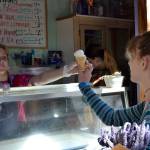 Meg Vander Velde of Purple Haze Lavender Farm serves ice cream to Ella Bivens of Lynden on July 21. It was Bivens first taste of lavender ice cream, she said. Sequim Gazette photo by Matthew Nash