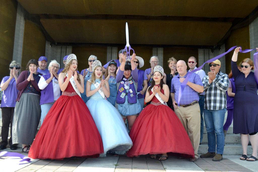 Debbie Madden, executive director of the Sequim Lavender Festival, cuts the ribbon with community members and Irrigation Festival royalty on July 19 to open the festival and Street Fair. Sequim Gazette photo by Matthew Nash