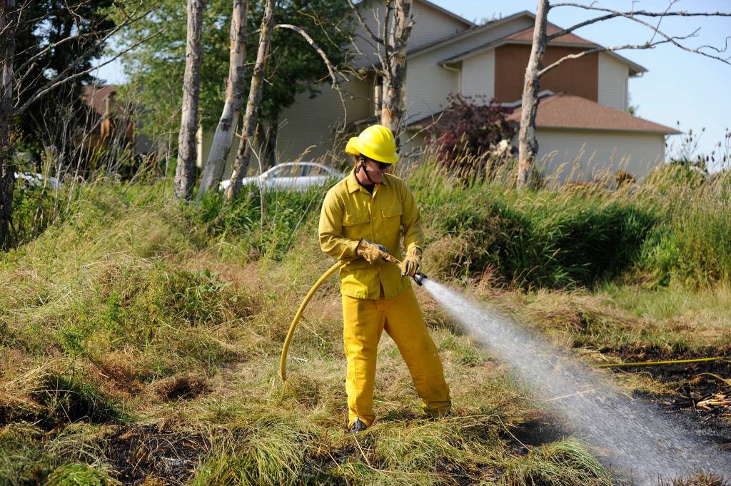 Jack Hueter, firefighter/paramedic with Clallam County Fire District 3, helps extinguish a brush fire on July 19. Sequim Gazette photos by Matthew Nash