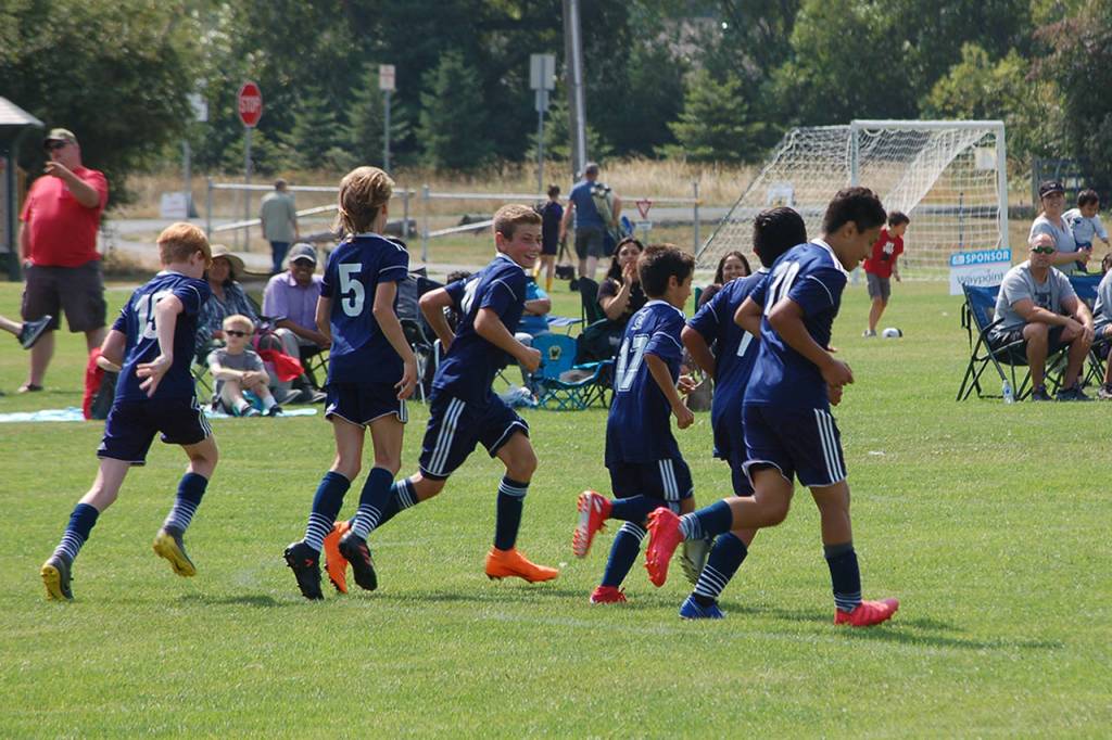 Members of the Storm King Cyclones U13-U14 team celebrate a late goal scored against the TCRT Alliance. They went on to win that match 4-3 in a close game that featured four late goals, then faced TCRT again in the division final, winning the championship in a 5-2 match. Sequim Gazette photo by Conor Dowley.