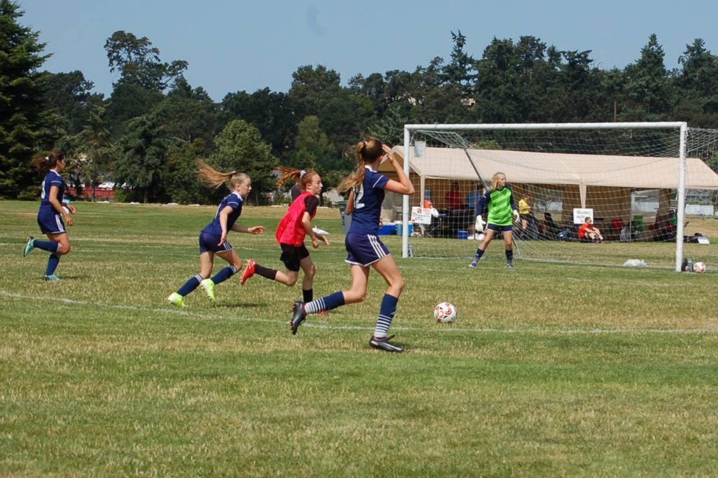 Storm King girls U14 defenders (blue shirts) get back to defend a counter-attack from Harbor Youth Soccer attackers (red vest). Storm King went on to win that match 5-0, and ultimately won the division championship in a 3-1 win over the Tracyton Force. Sequim Gazette photo by Conor Dowley.