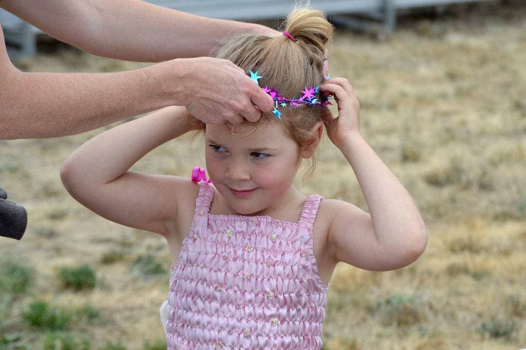 Azlyn Blessington, 4, gets help from her mom Carolyn Raleigh to put on her new crown dressed as a fairy princess at the Princess Storytime. Sequim Gazette photo by Matthew Nash