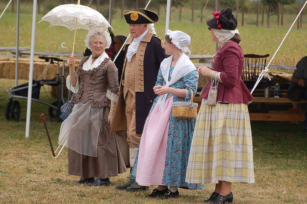 Vern Frykholm (portraying George Washington), second from left, stands alongside Jane Ritchey (Martha Washington), Laury Long (Esther Reed) and Lucy Keegan (Eliza Pinckney) as they observe the reenactment.