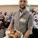 Event volunteer Erik Kingfisher carries a platter of local foods at the 2018 Friends of the Fields Harvest Dinner. Photo courtesy North Olympic Land Trust