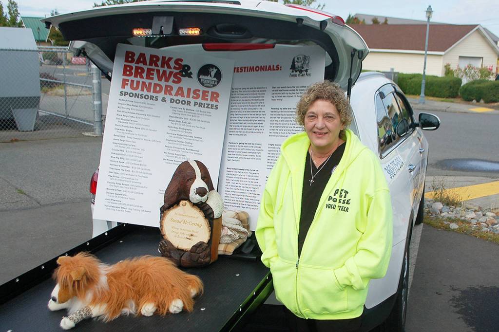 Pet Posse founder Shelléy Van Cleave stands with the organizations veterinary transport, a specially-modified SUV to help take even the largest dog breeds safely to a veterinarian. The transportation service is available to anyone who needs it, especially in emergency situations. Sequim Gazette photo by Conor Dowley