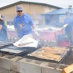 Left, Rotarians look over salmon fillets at the 2019 Rotary Club of Sequim Salmon Bake on Aug. 11. Above, Stuart and Janet McColl take a turn on the dance floor as the Dukes of Dabob play at theevent held at the Sequim Boys & Girls Club. Sequim Gazette photos by Michael Dashiell